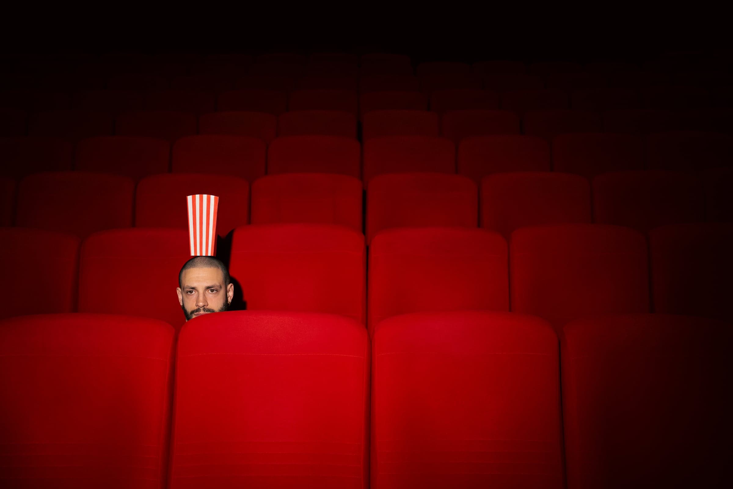 Eddie Cudi, popcorn sur la tête, dans une salle de cinéma