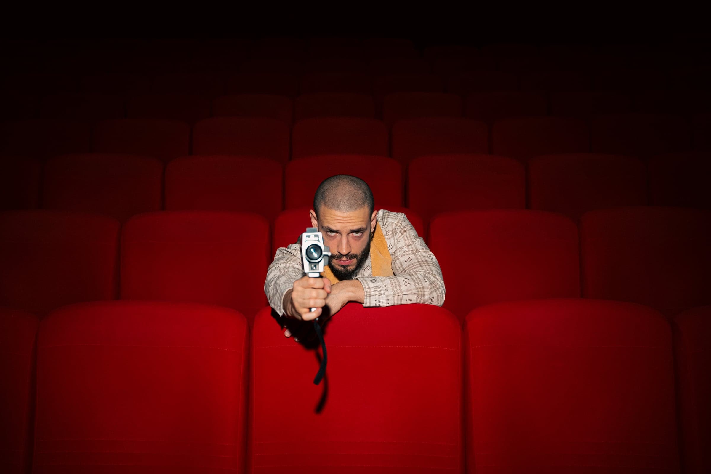 Eddie Cudi derrière une caméra, dans une salle de cinéma