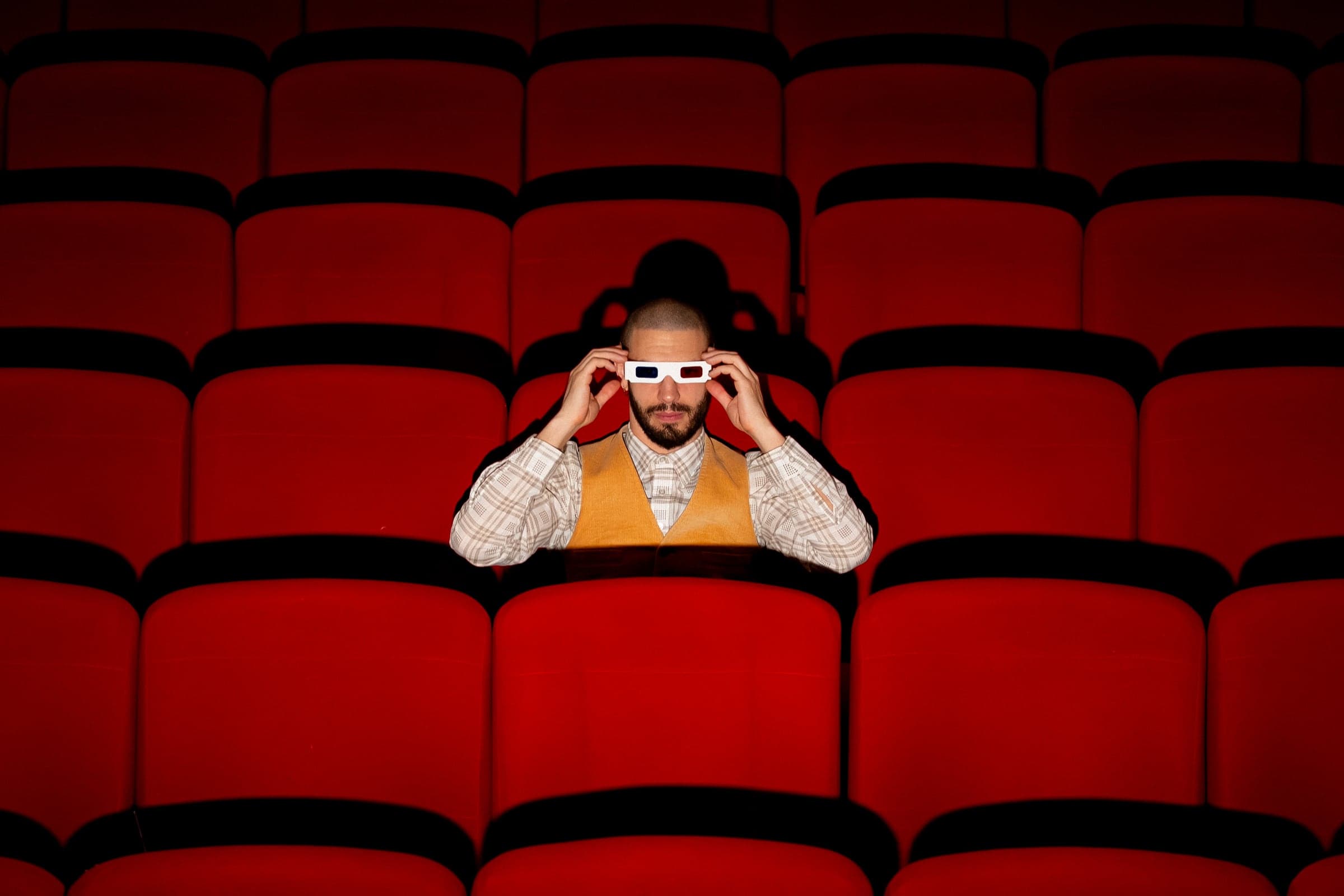 Eddie Cudi avec des lunettes 3D, dans une salle de cinéma